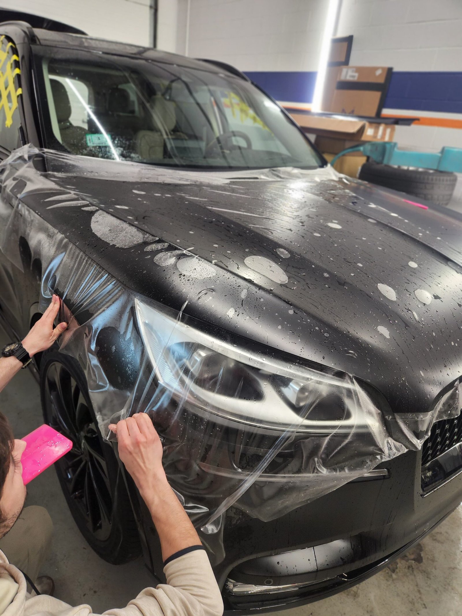 Tint Nation Company Technician applying car wrap at Tint Nation in Massachusetts, showcasing expertise and precision